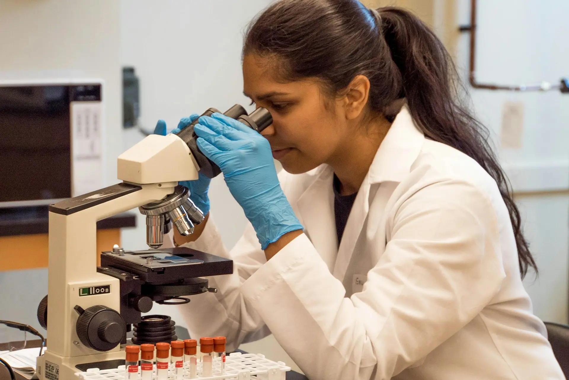 Personalised Supplements woman looking on microscope inside room